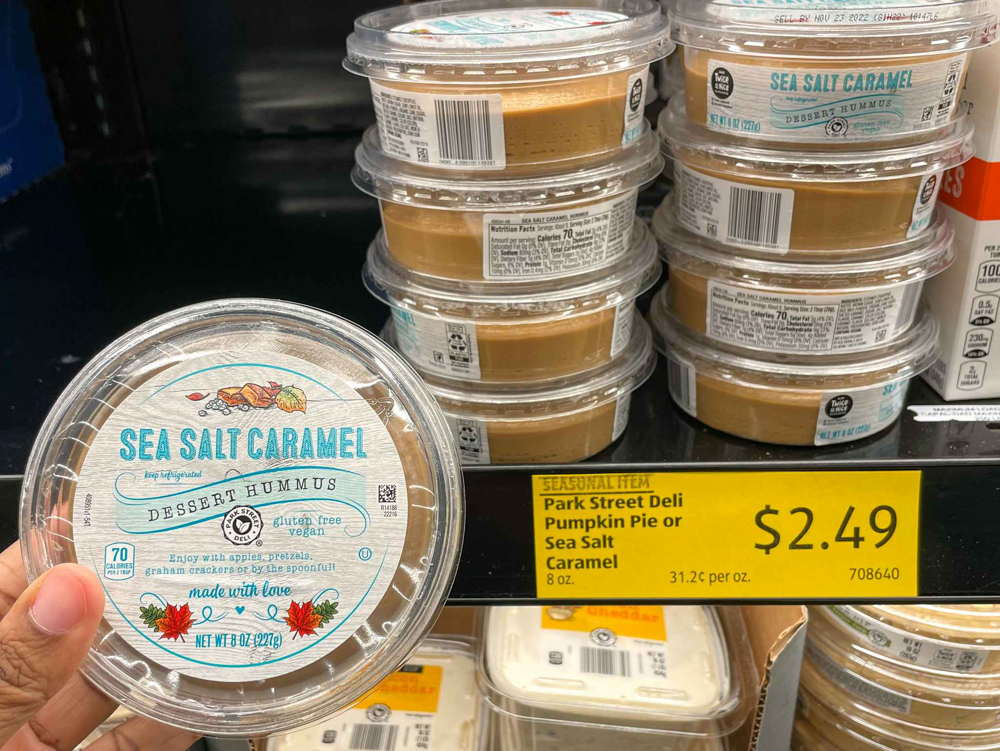 hummus hand held near sale sign at aldi