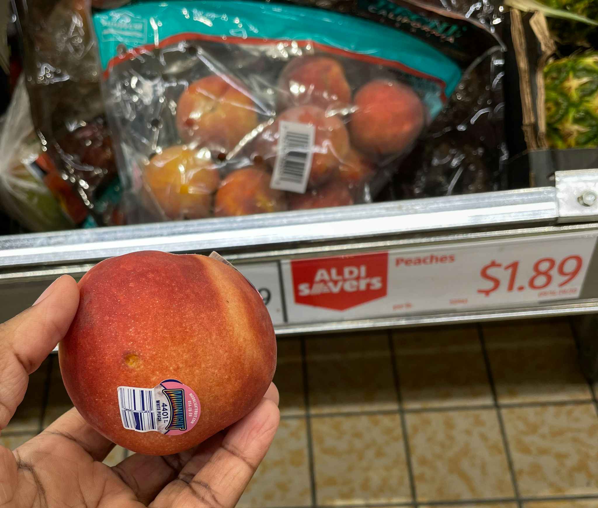 peach hand held near sale sign at aldi