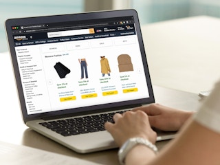 A person using a laptop, looking at the Fashion coupons available on Amazon.