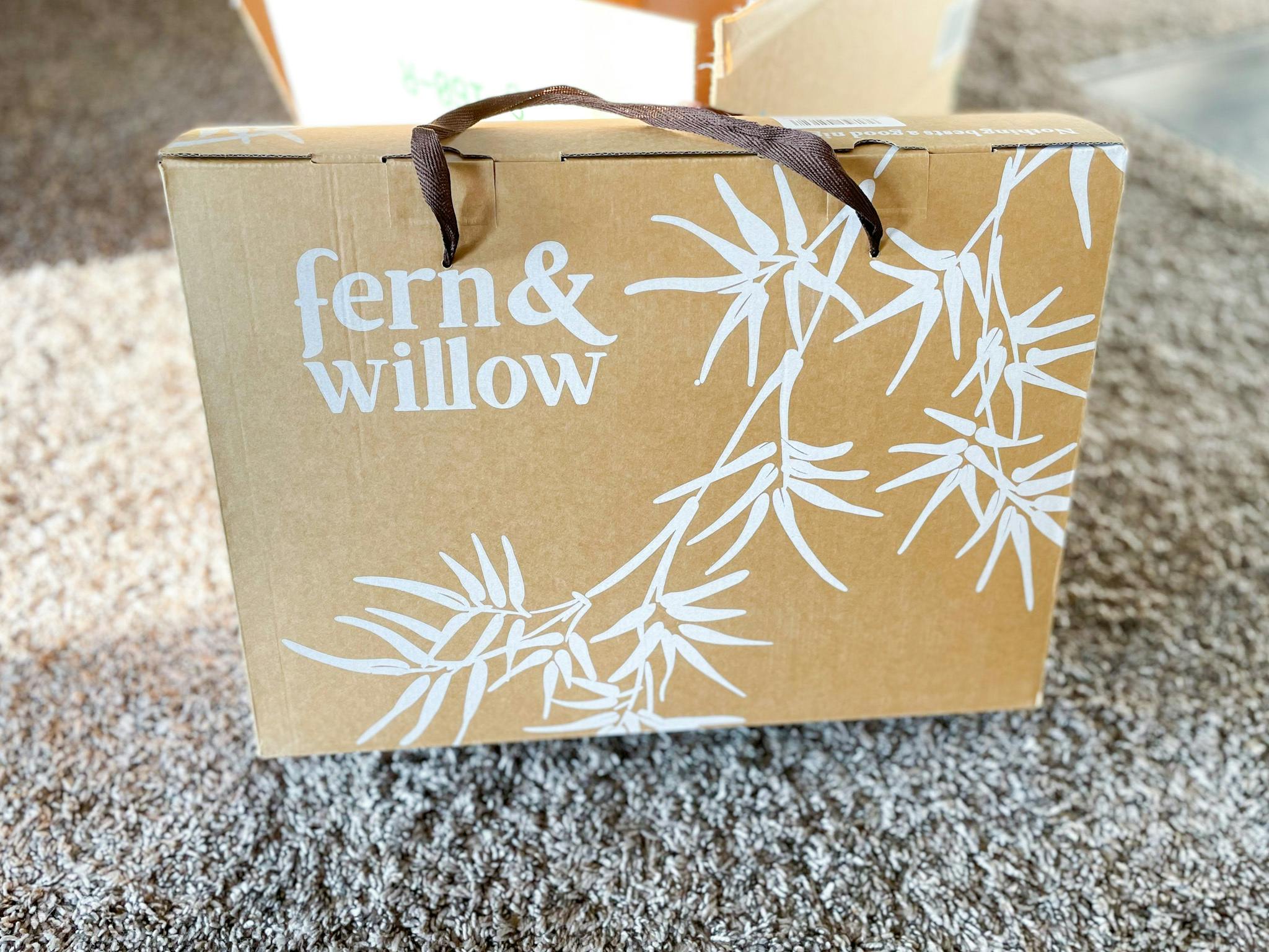 A box of Fern and Willow pillows in front of an open delivery box.