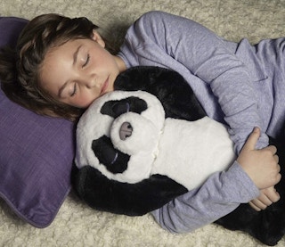 A young girl holding a FurReal panda cub.