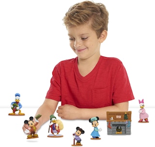 A boy playing with a Disney Christmas Carol playset.