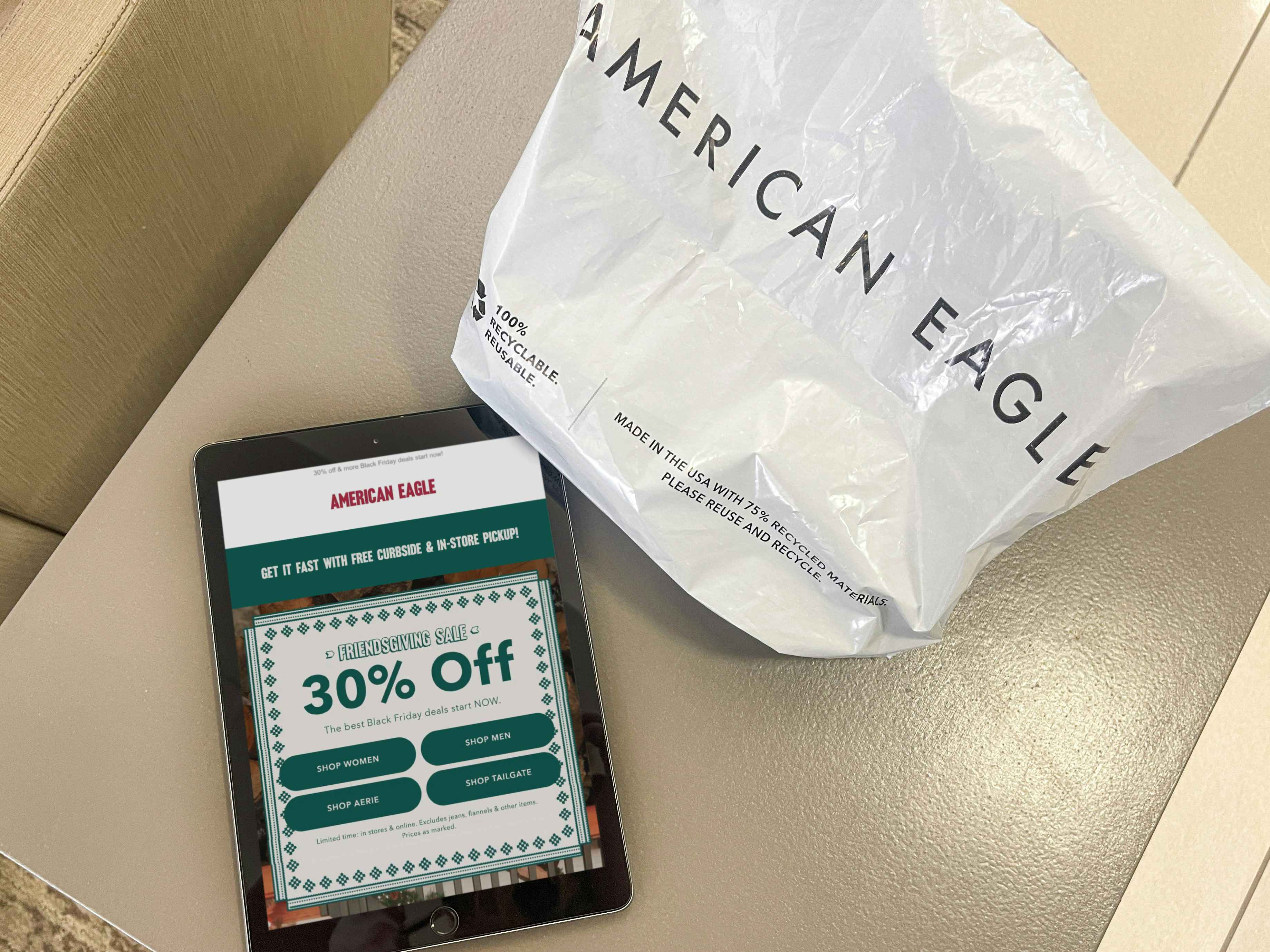a ipad with american eagle ad on table next to shopping bag 