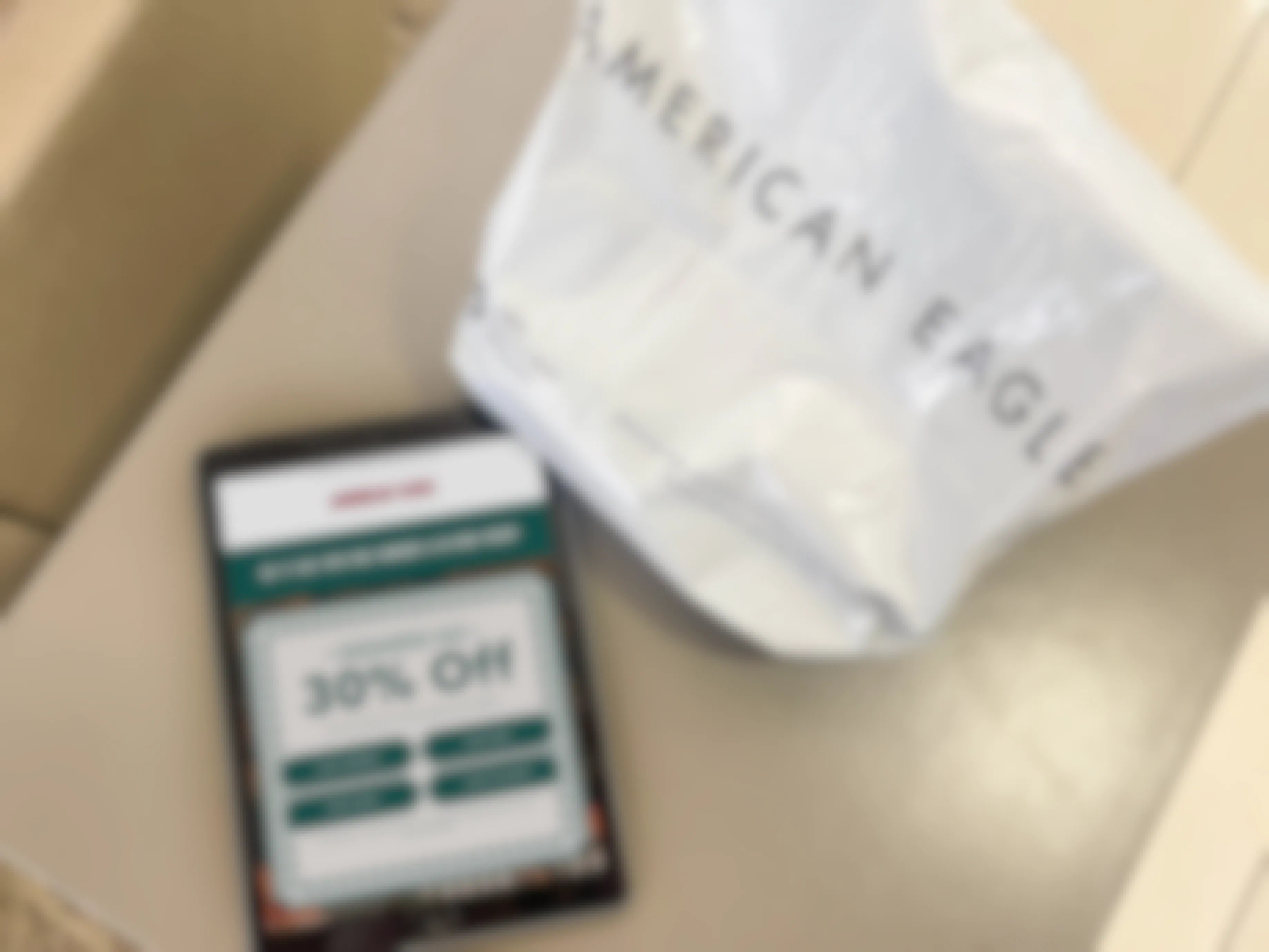 a ipad with american eagle ad on table next to shopping bag 