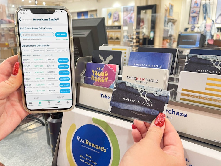 a person holding up an American Eagle gift card next to a cellphone displaying the Raise app.
