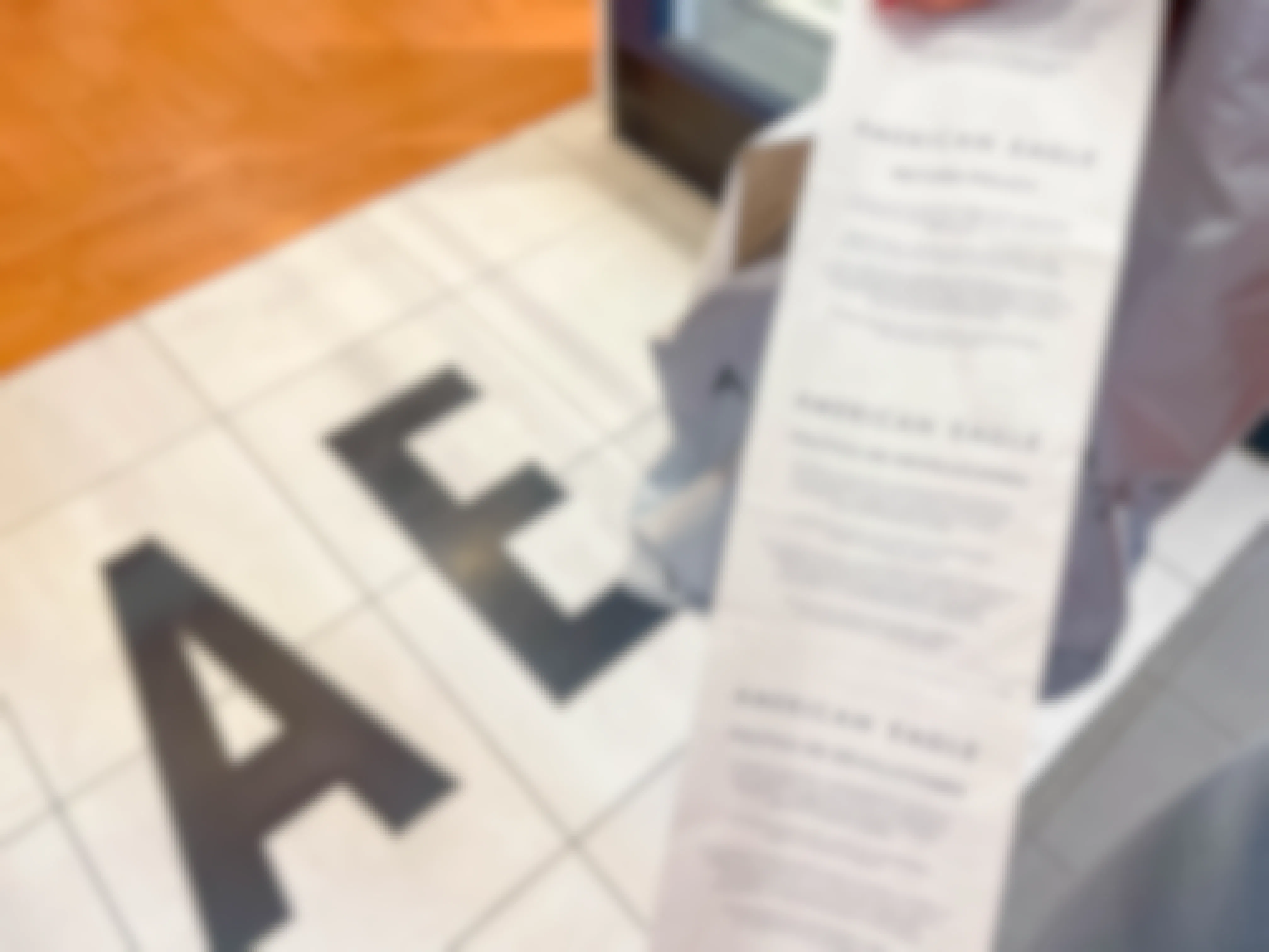An American Eagle receipt being held showing the return policy on the back in the store entrance