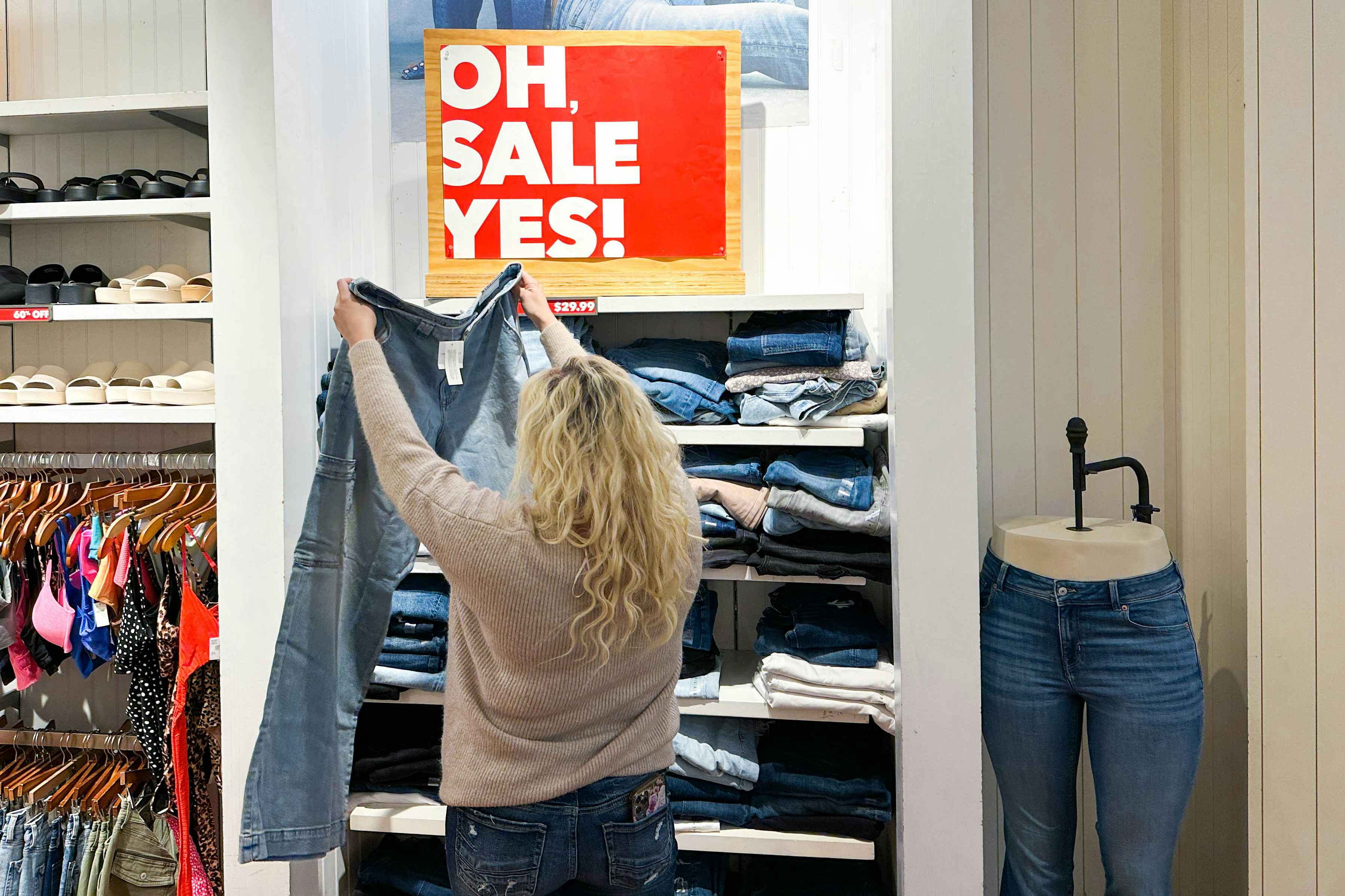 a woman looking at jeans on sale in the amercan eagle store