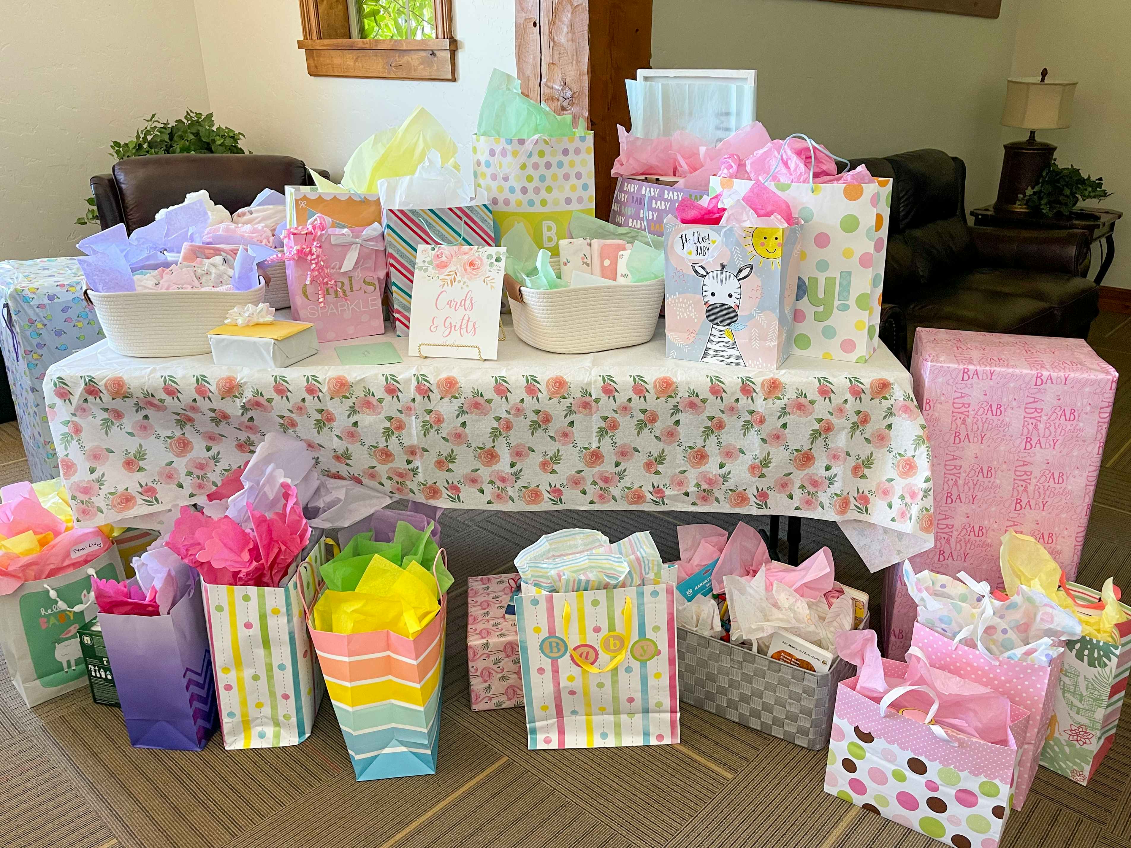 a gift table at a baby shower filled with gifts 