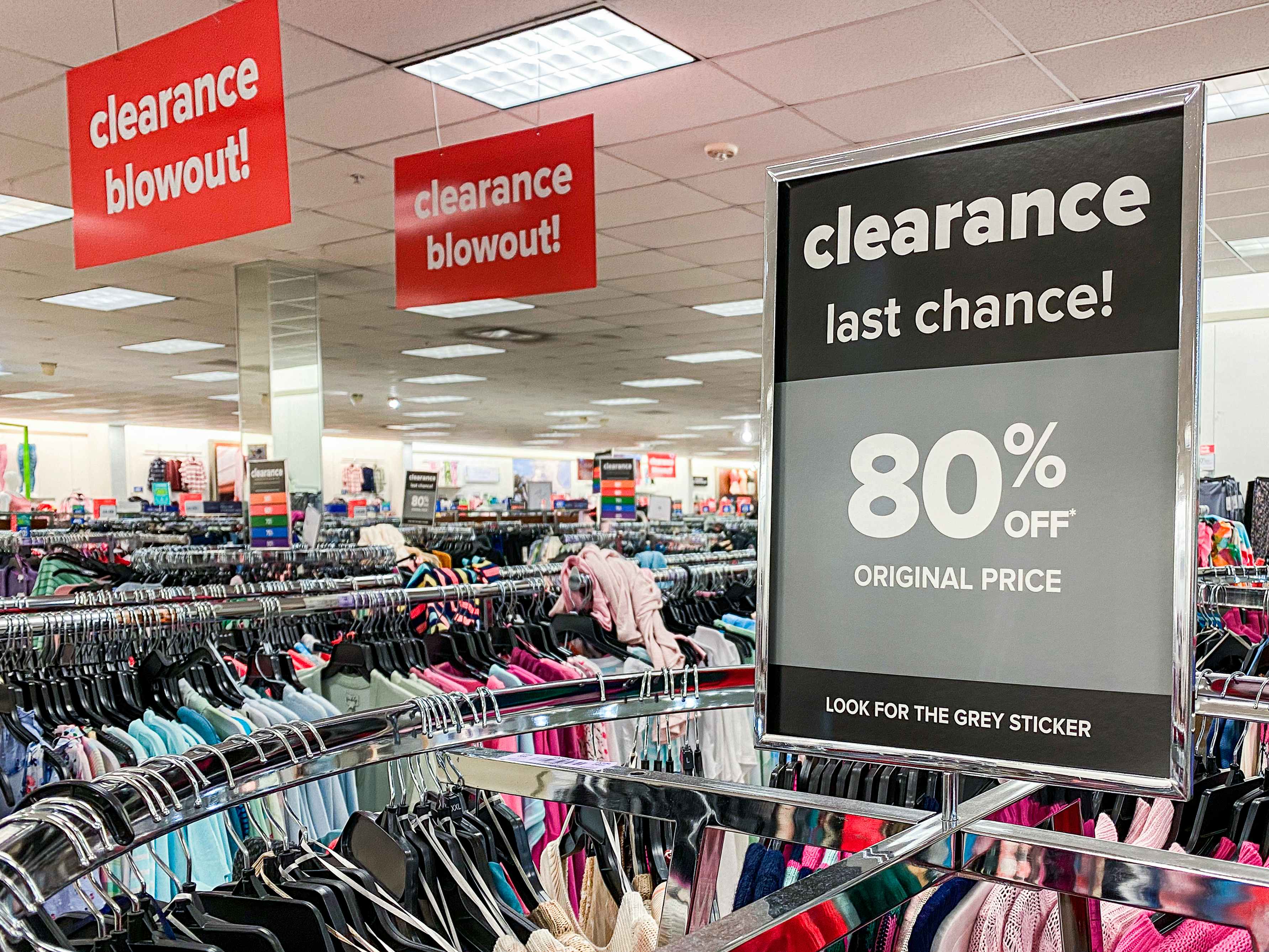 An 80% off Clearance sign affixed to a clothing rack at Belk.