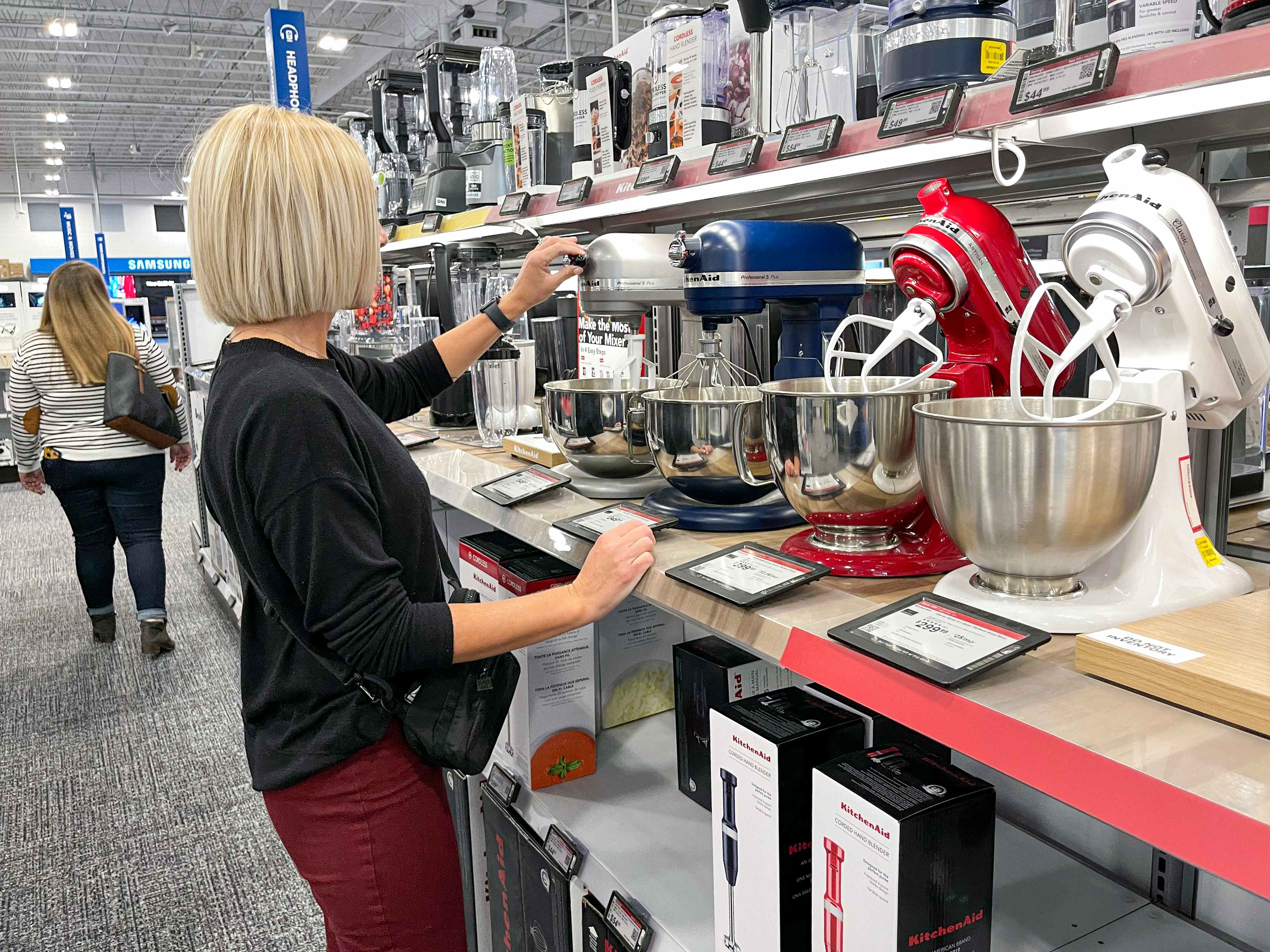 A woman looking at KitchenAid mixers at Best Buy