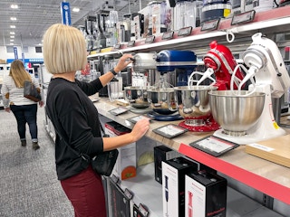 A woman looking at KitchenAid mixers at Best Buy