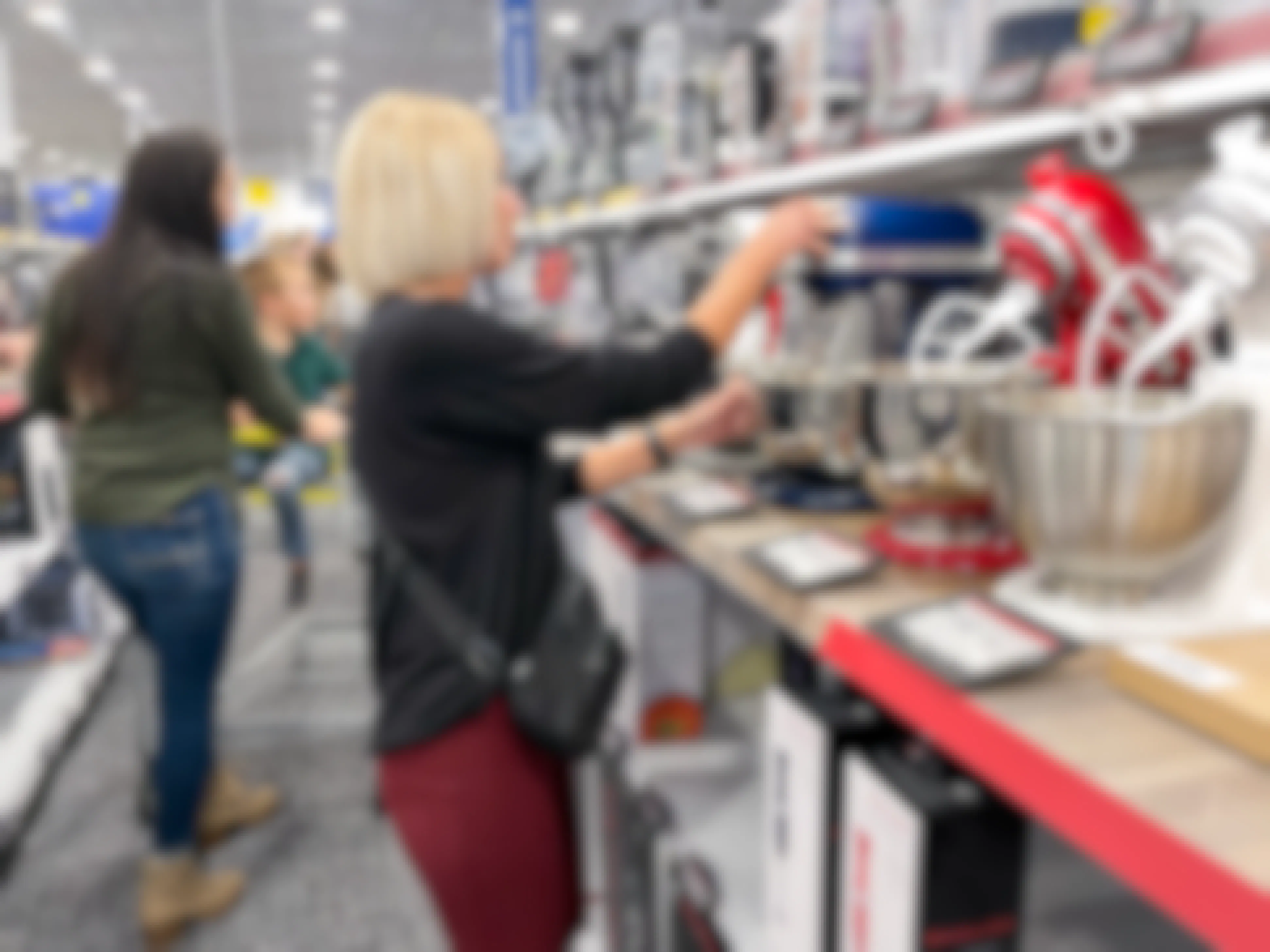 A woman looking at KitchenAid mixers at Best Buy