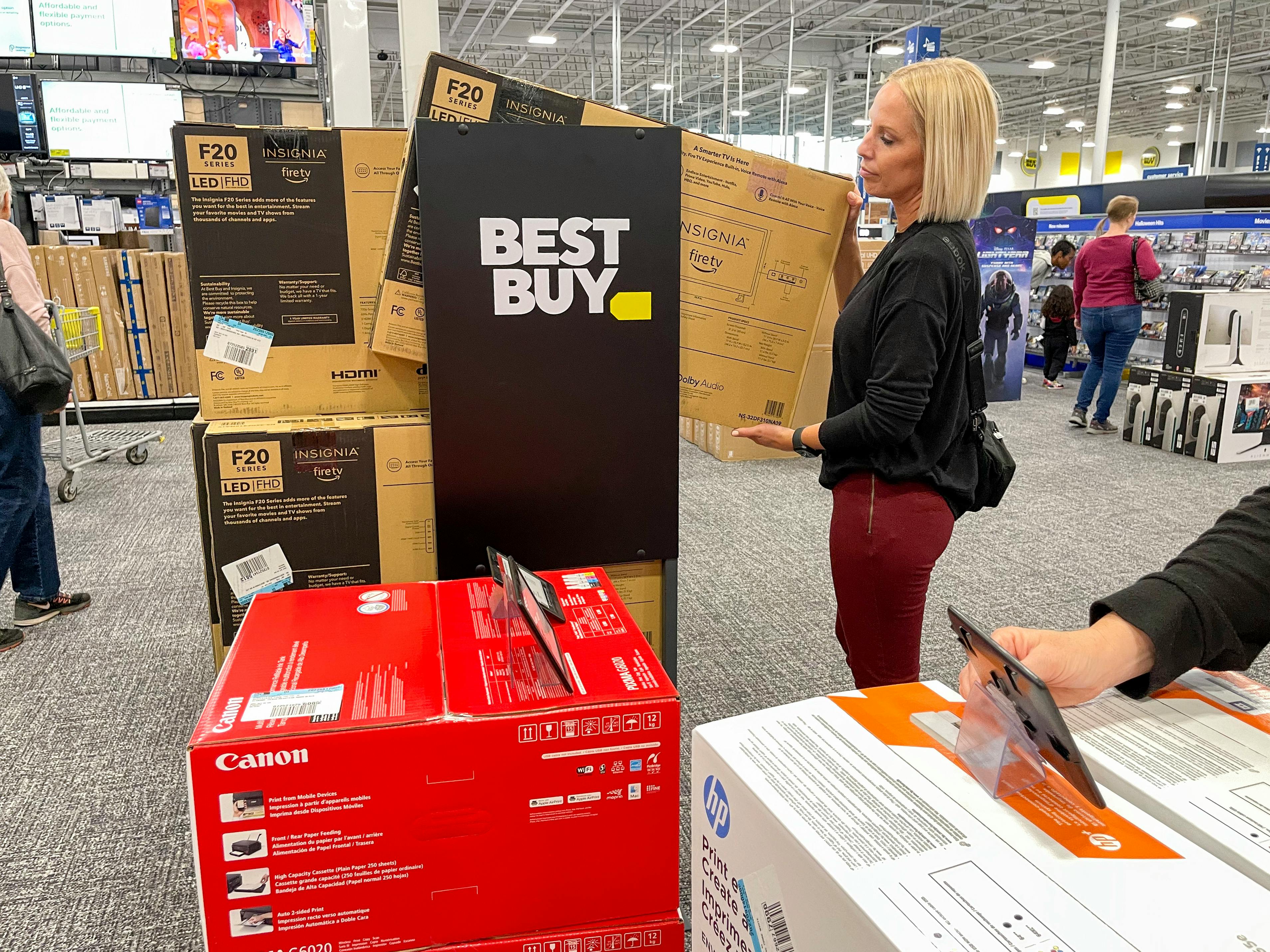 A woman in Best Buy looking at a TV.
