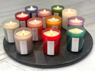 A set of fall candles from Costco all lit on a circle tray.