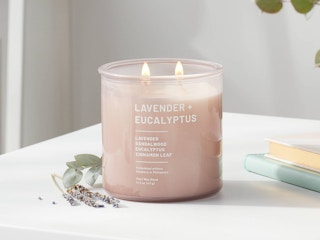 A lit Project 62 candle from Target sitting on a counter.