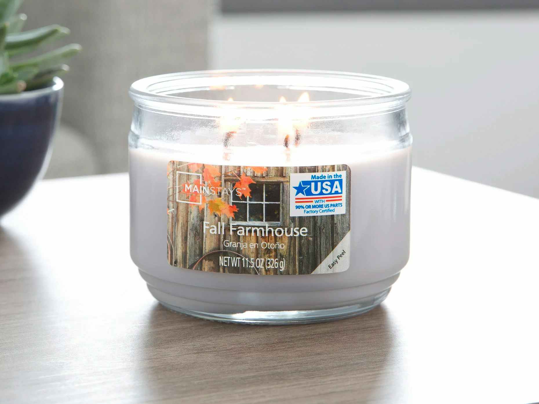 A lit Mainstays fall candle from Walmart sitting on a table.