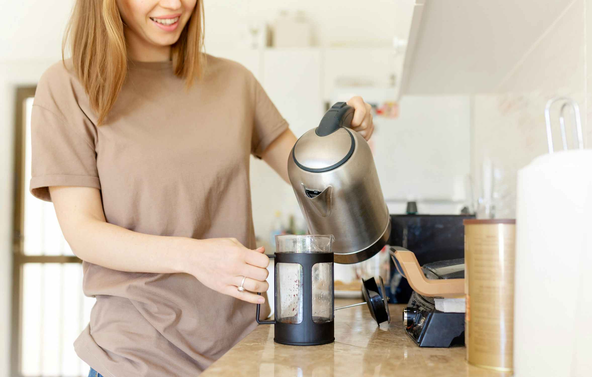 woman at home pouring coffee from french press