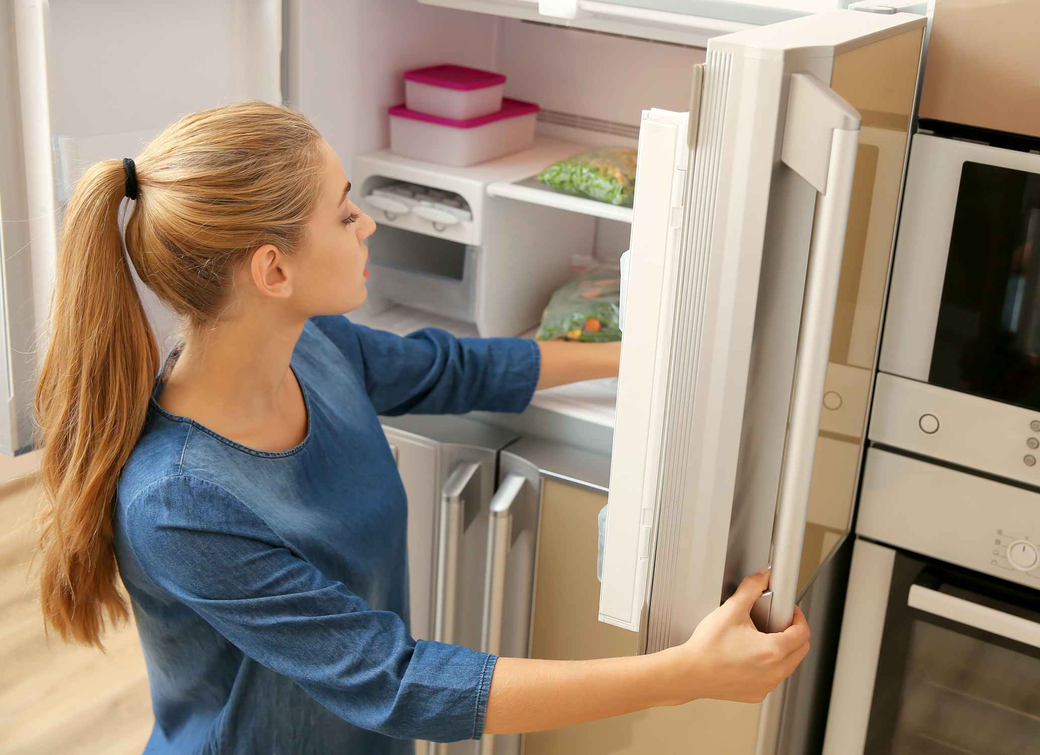 woman looking in freezer for food