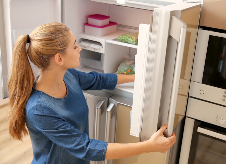 woman looking in freezer for food