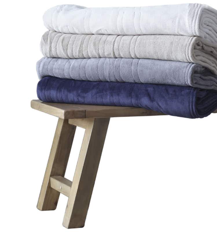 a stack of heated electric blankets in blues and white