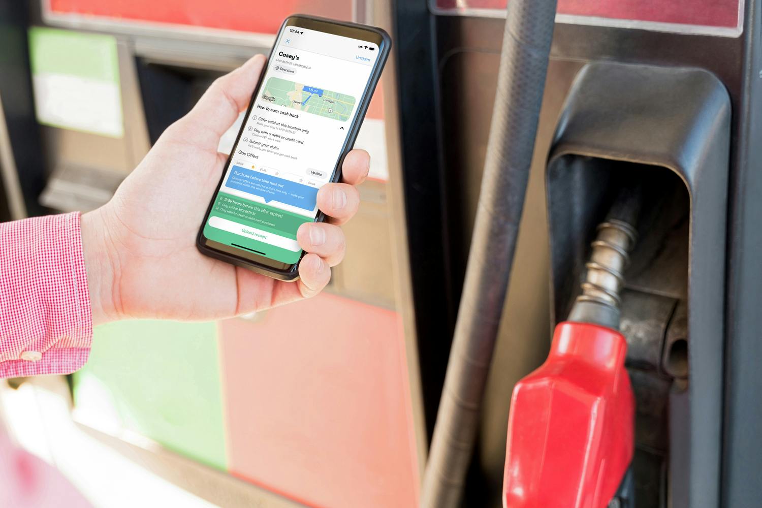 person at gas pump with phone displaying upside app