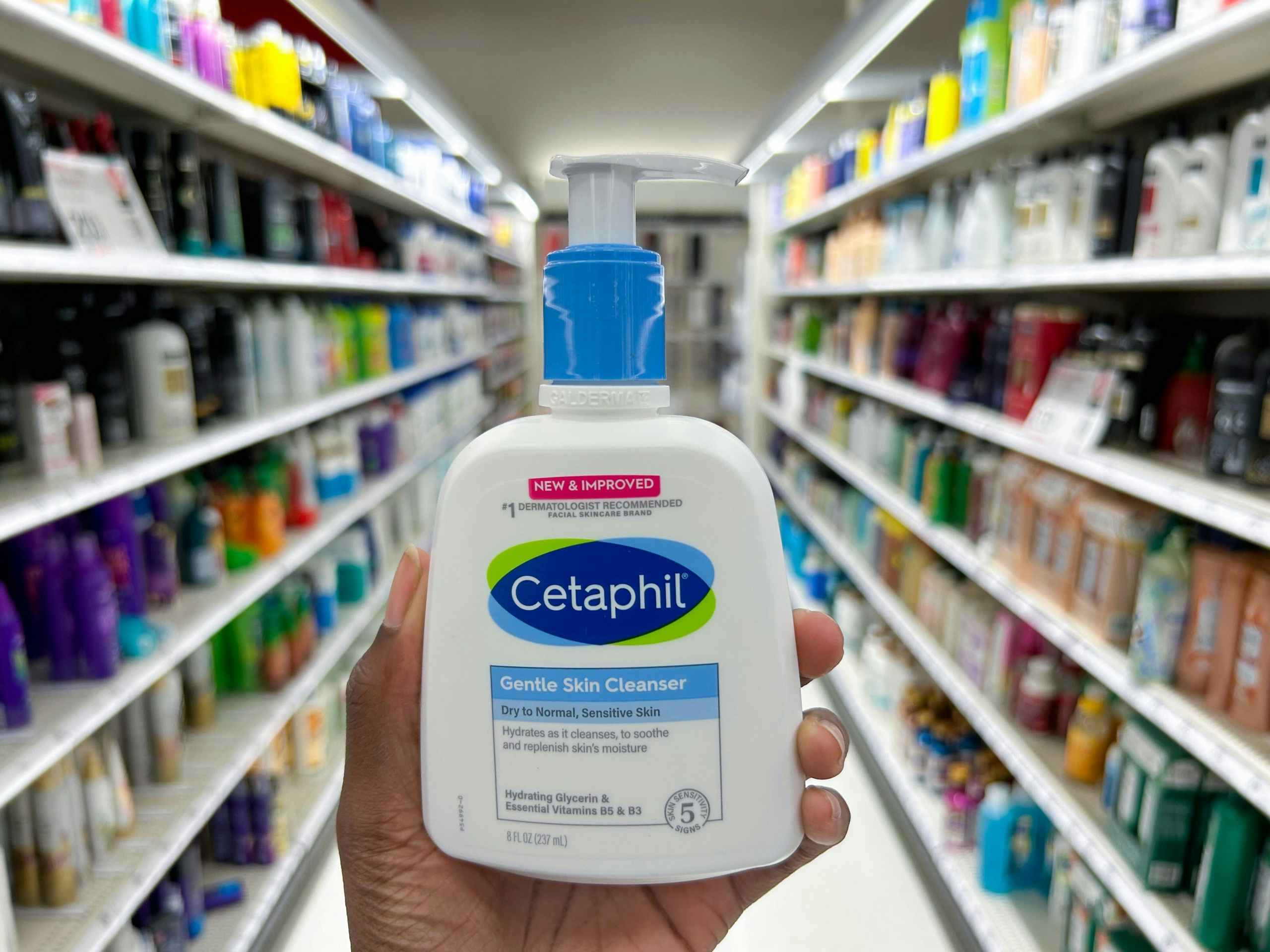hand holding cetaphil in front of aisle