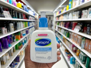 hand holding cetaphil in front of aisle