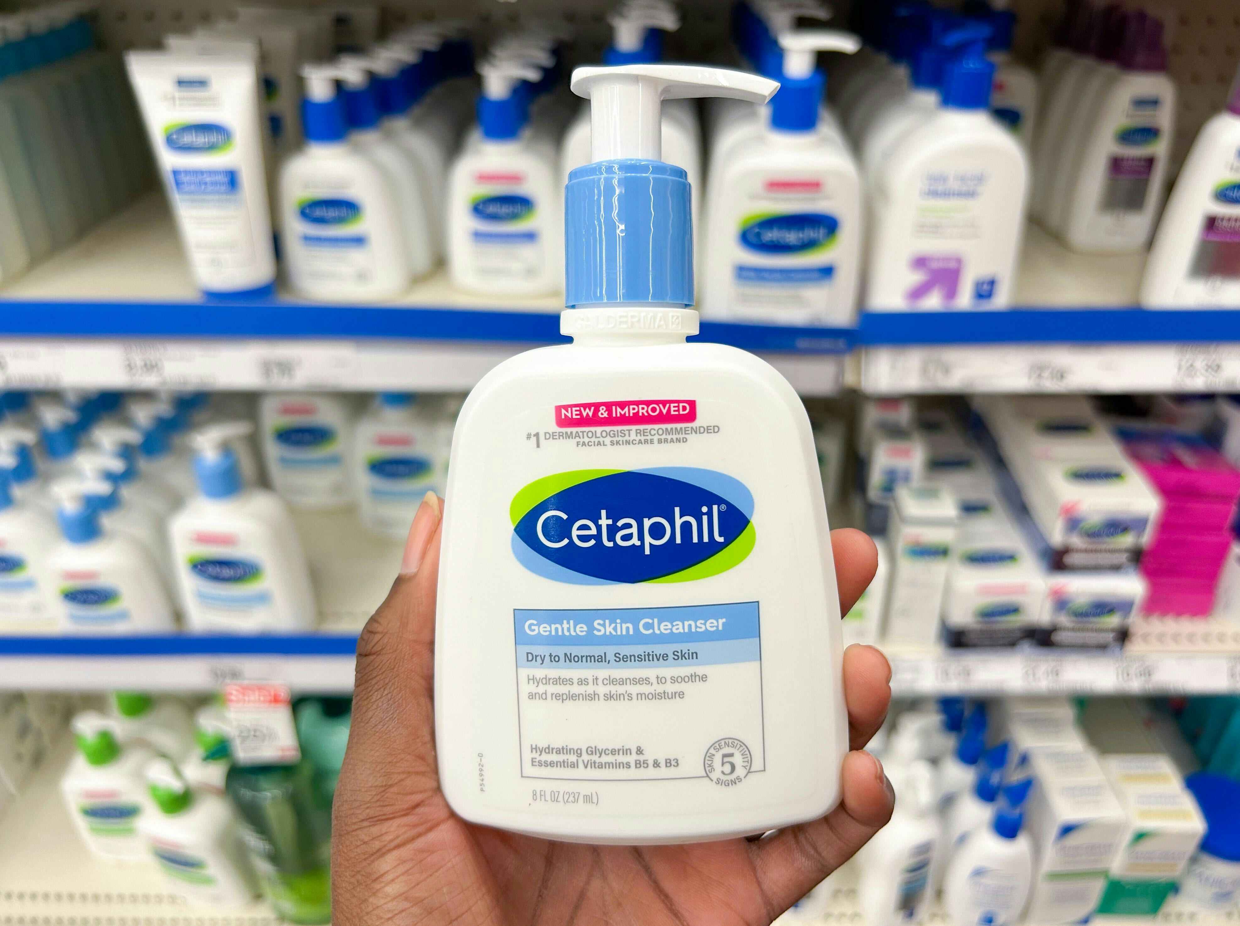 hand holding cetaphil directly in front of a shelf