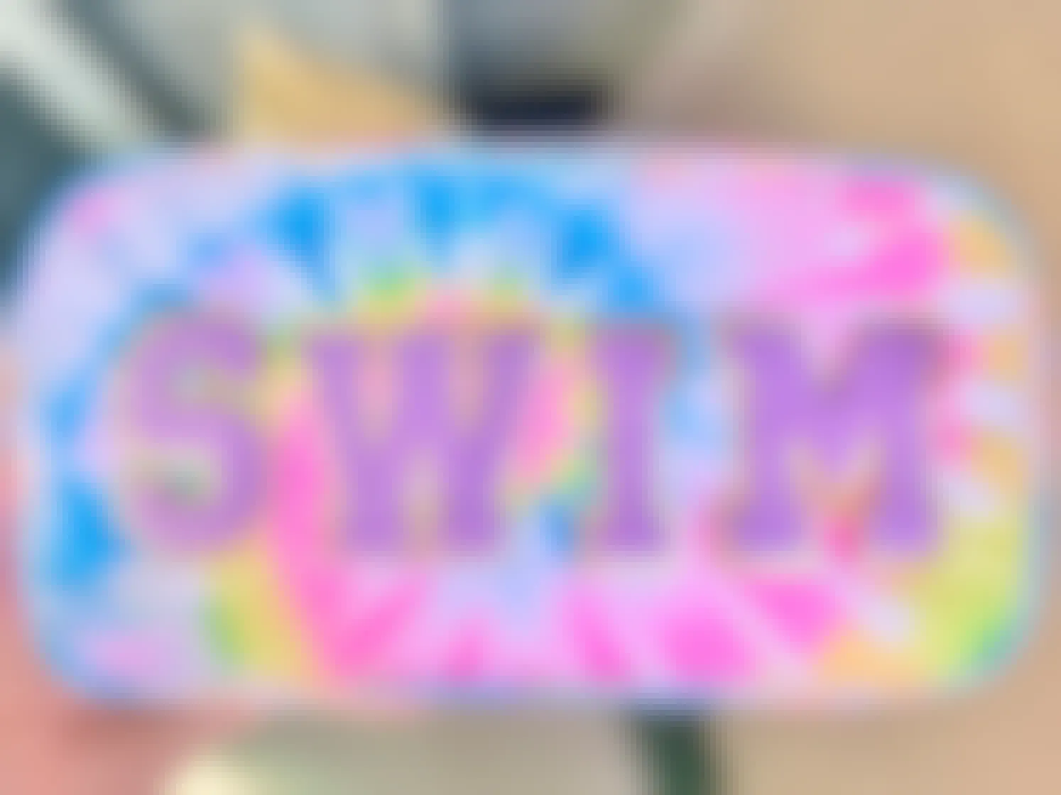 A custom tie-dye pouch with the word "swim" on the front in patches.