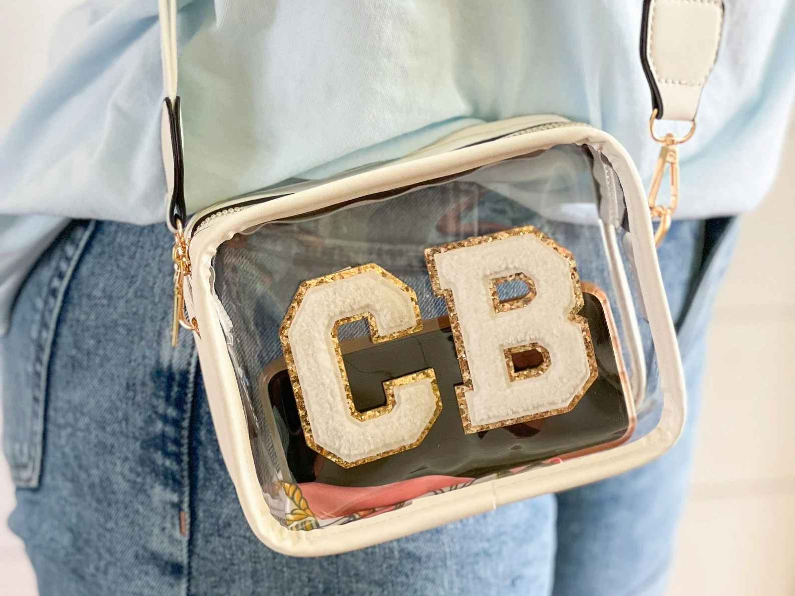 A person wearing a custom clear pouch with the letters CB on the front in patches.
