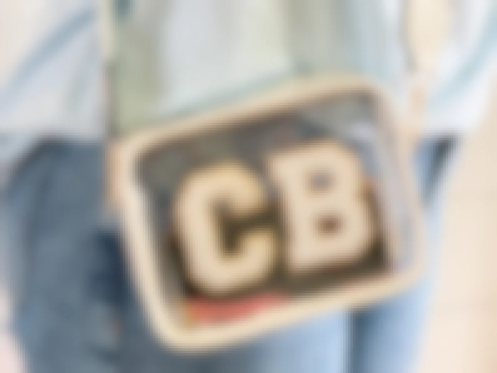 A person wearing a custom clear pouch with the letters CB on the front in patches.
