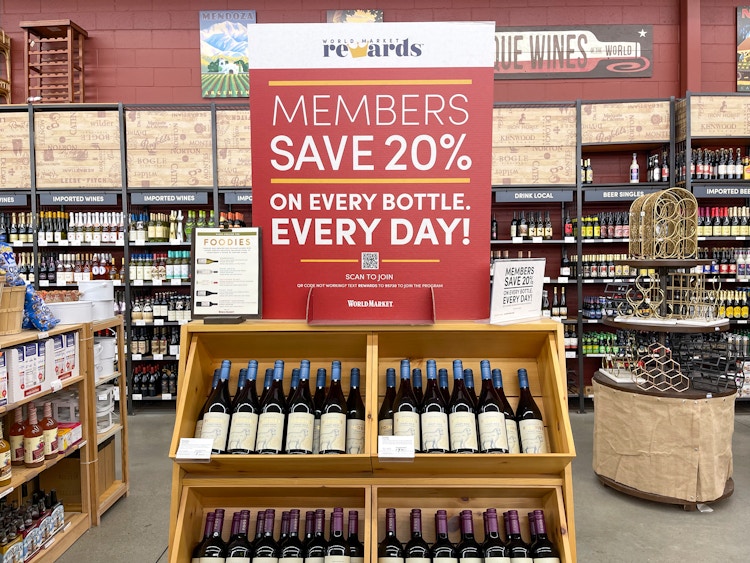 A sign for 20% off wine with the Cost Plus World Market rewards program membership.