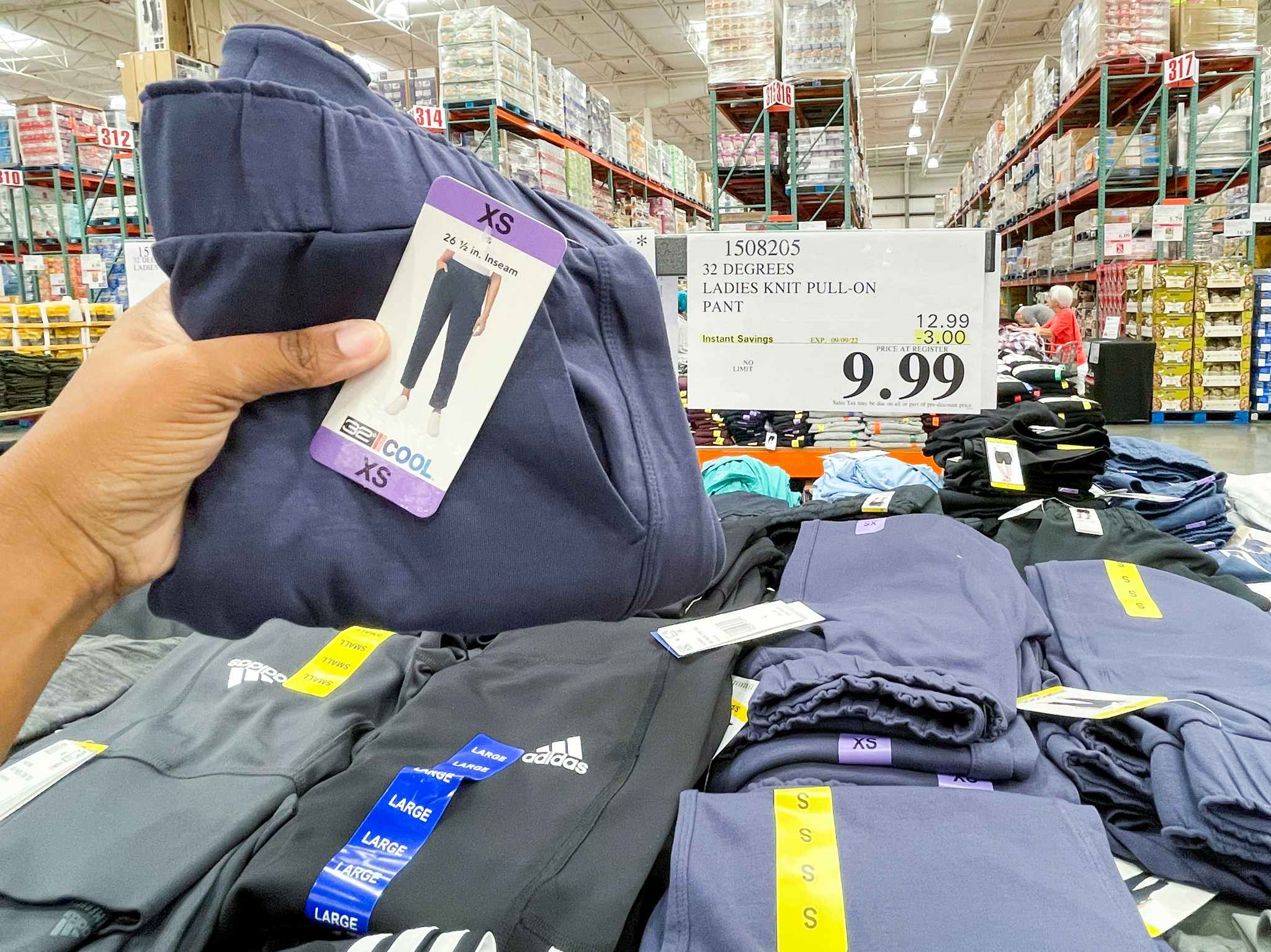 pant hand held near sale sign at costco