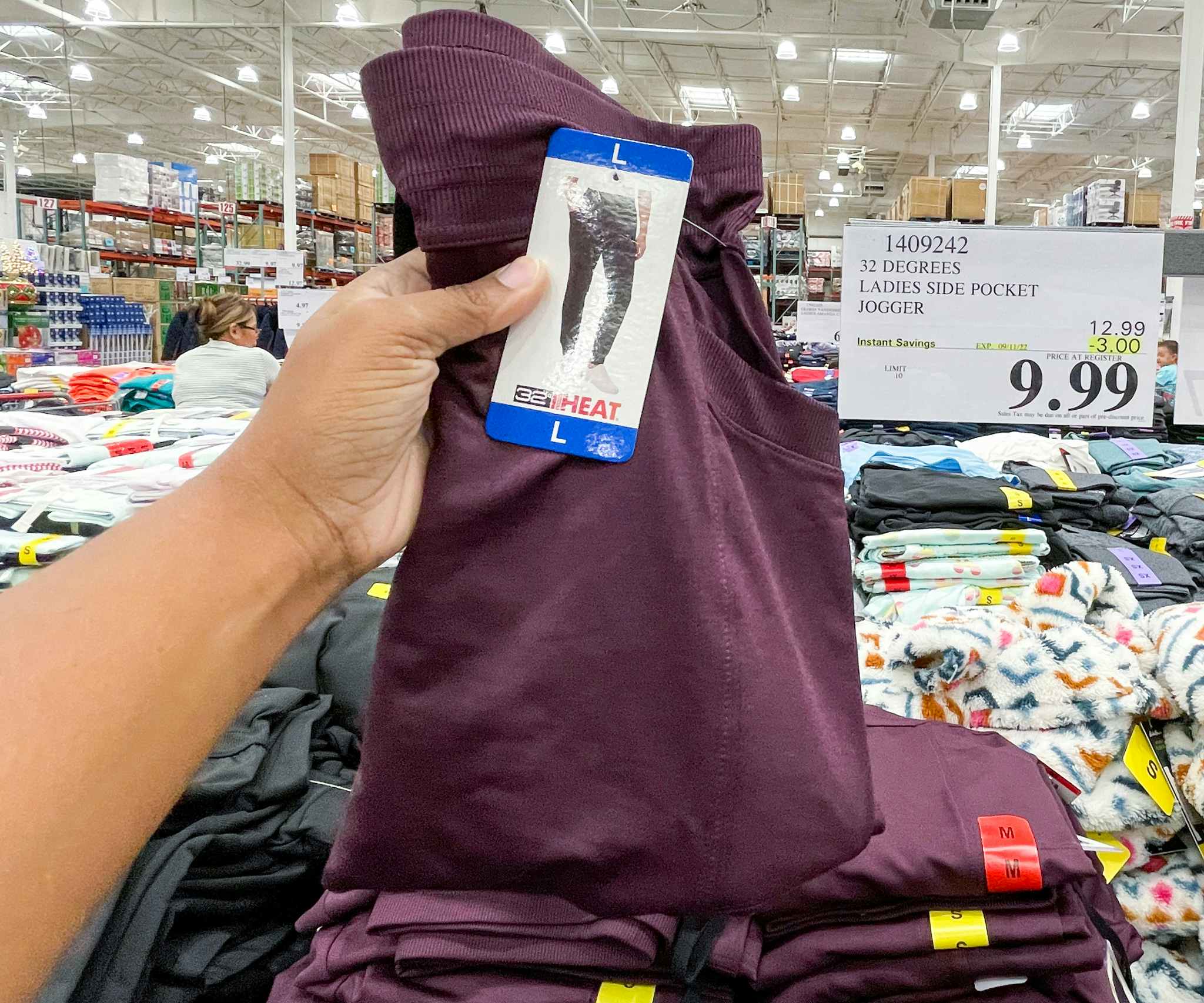 jogger hand held near sale sign at costco