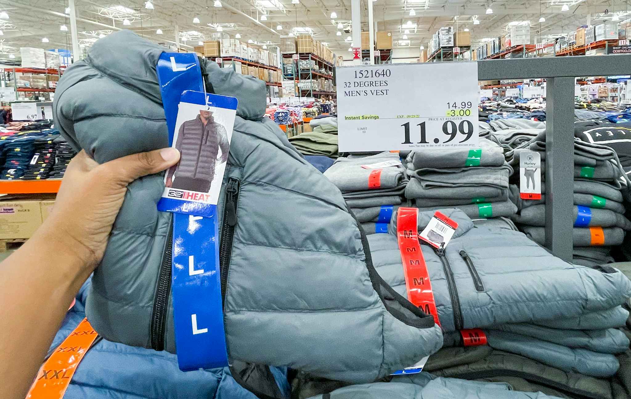mens vest hand held near sale sign at costco
