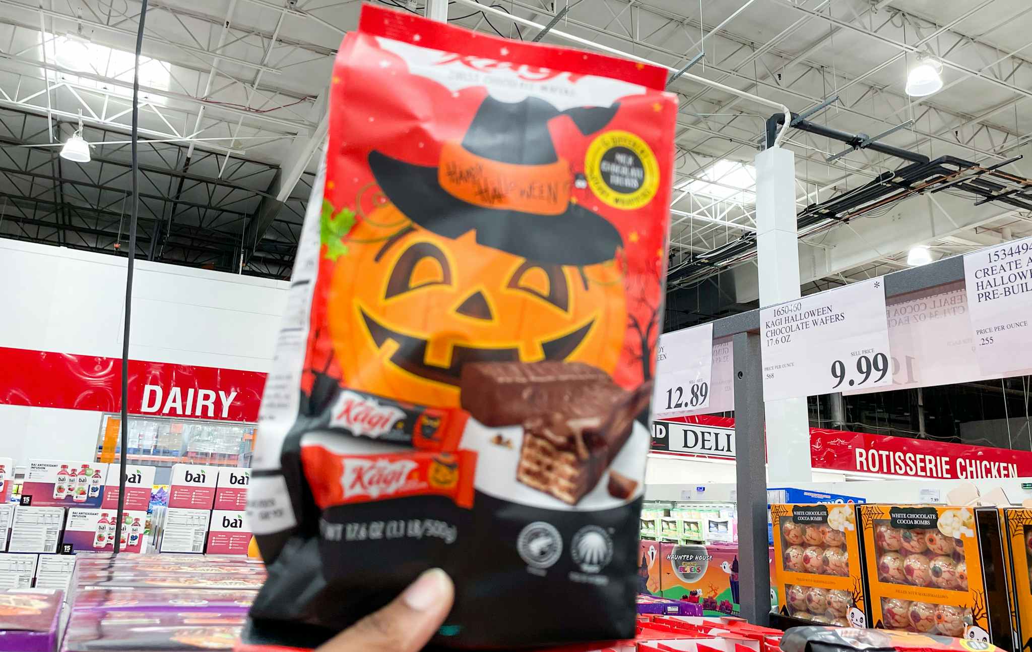 halloween wafers hand held near sale sign at costco