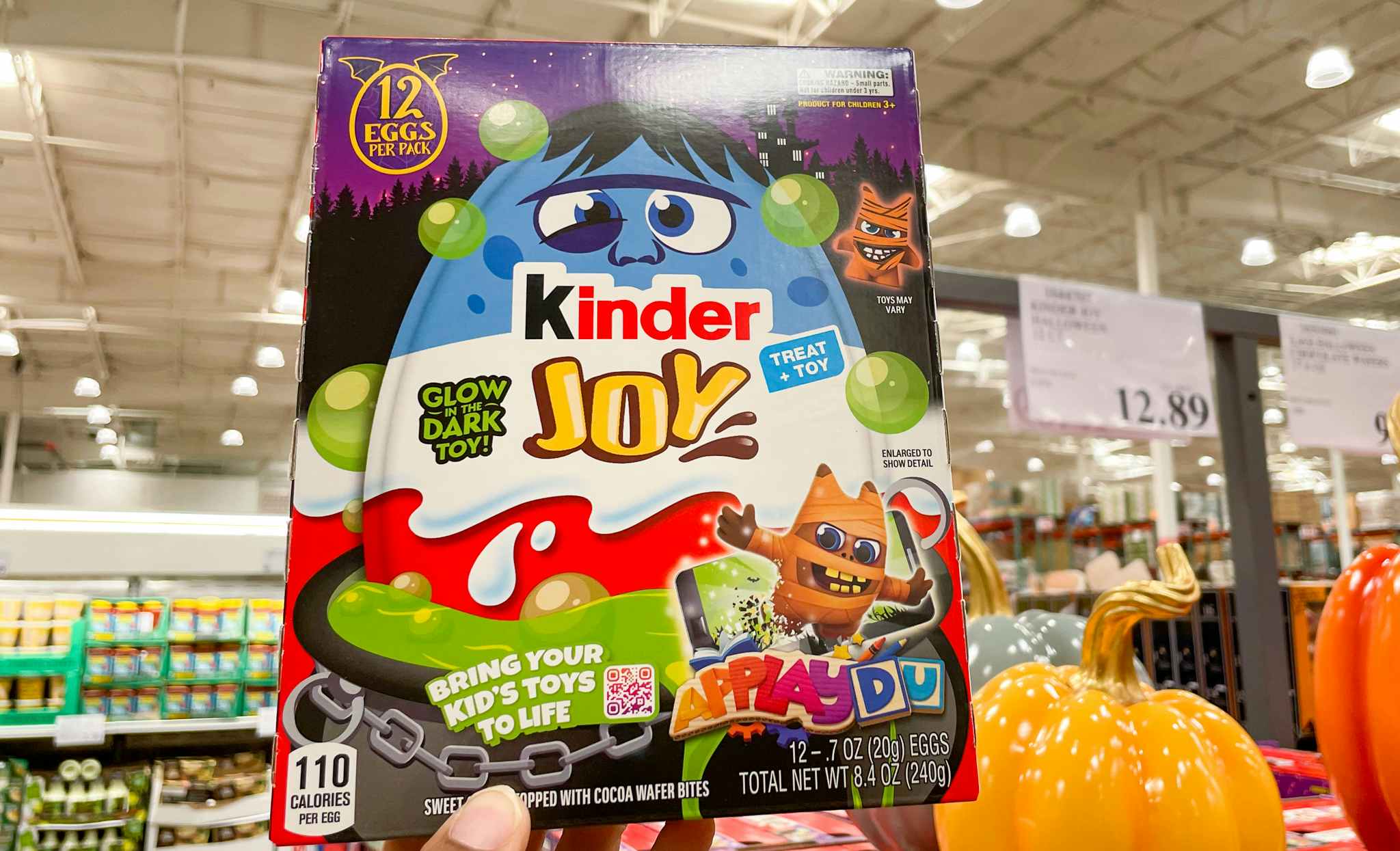 kinder joy eggs hand held near sale sign at costco