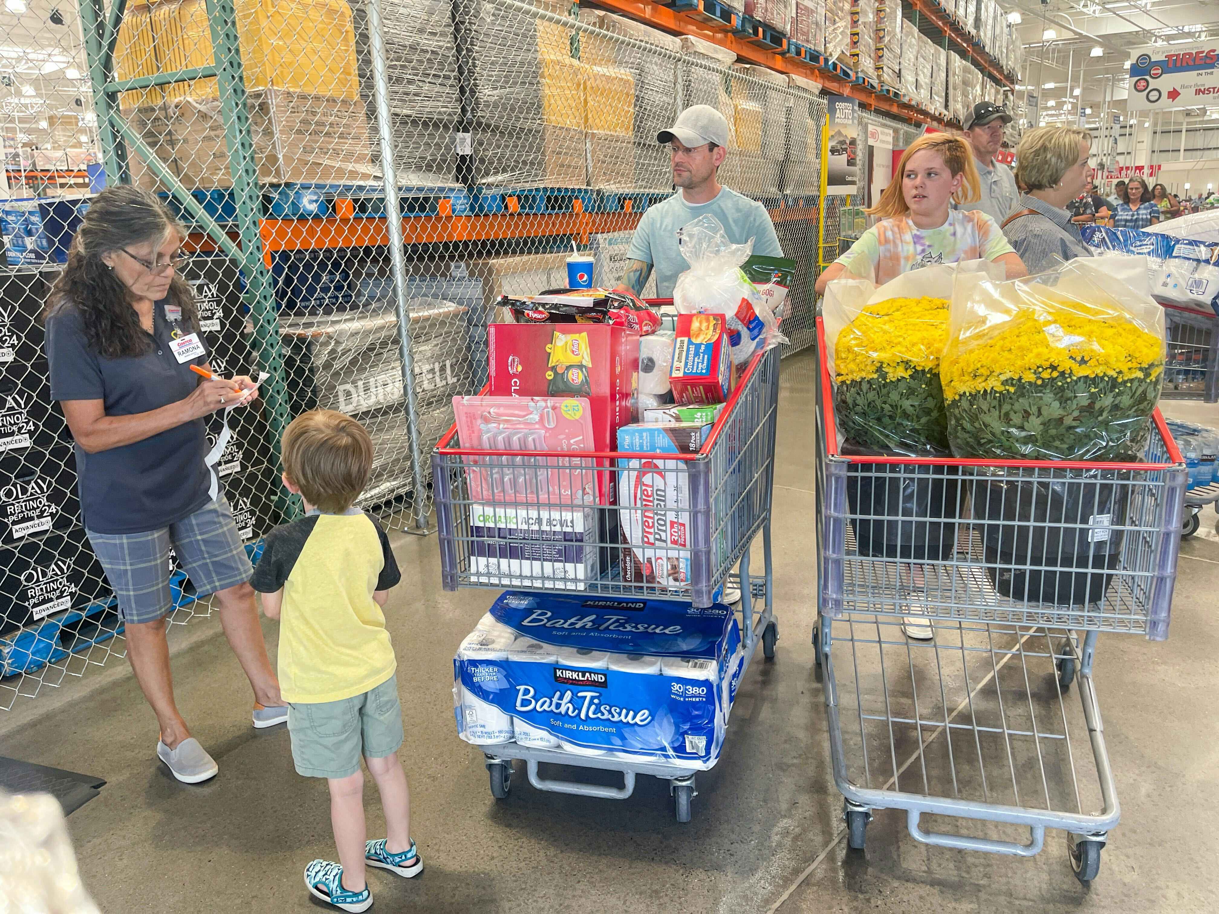 a family having the receipt checked at coctco with two carts