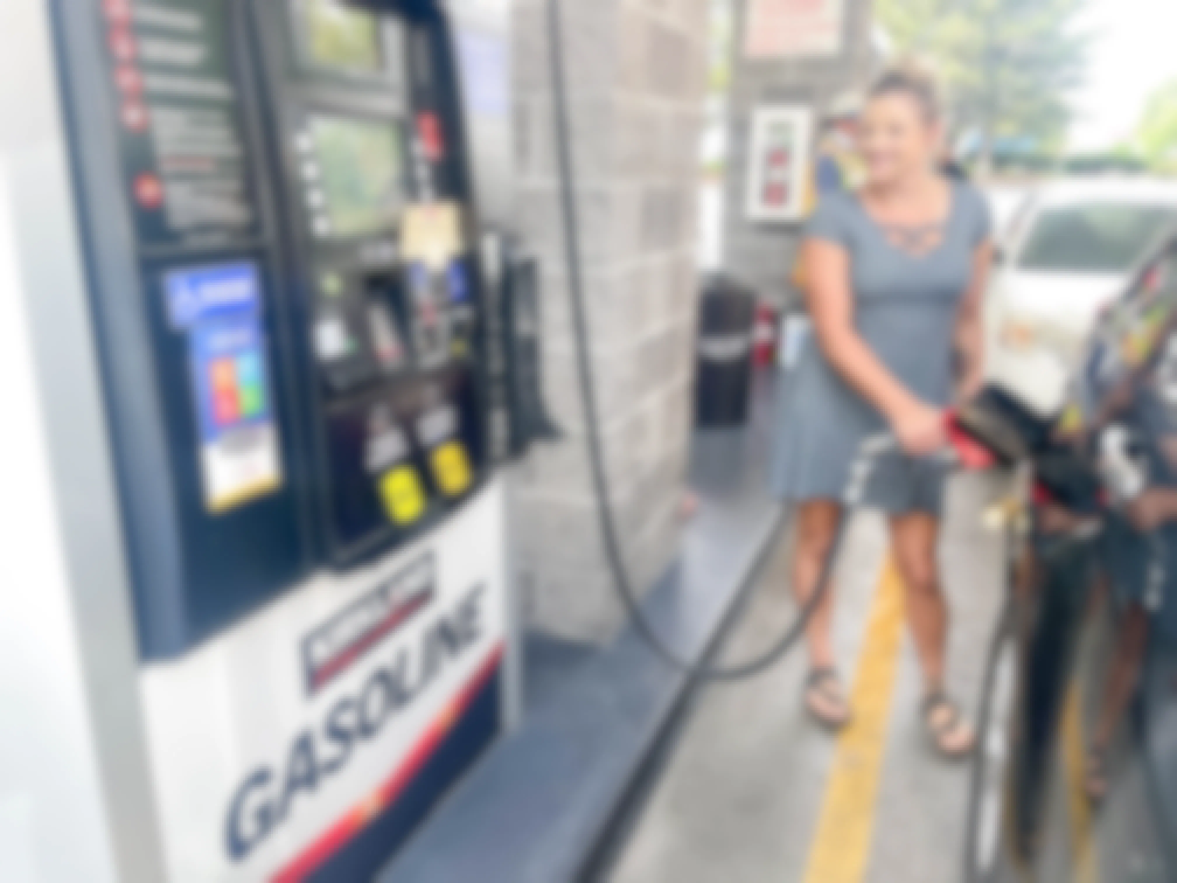 a woman pumping costco gas into car