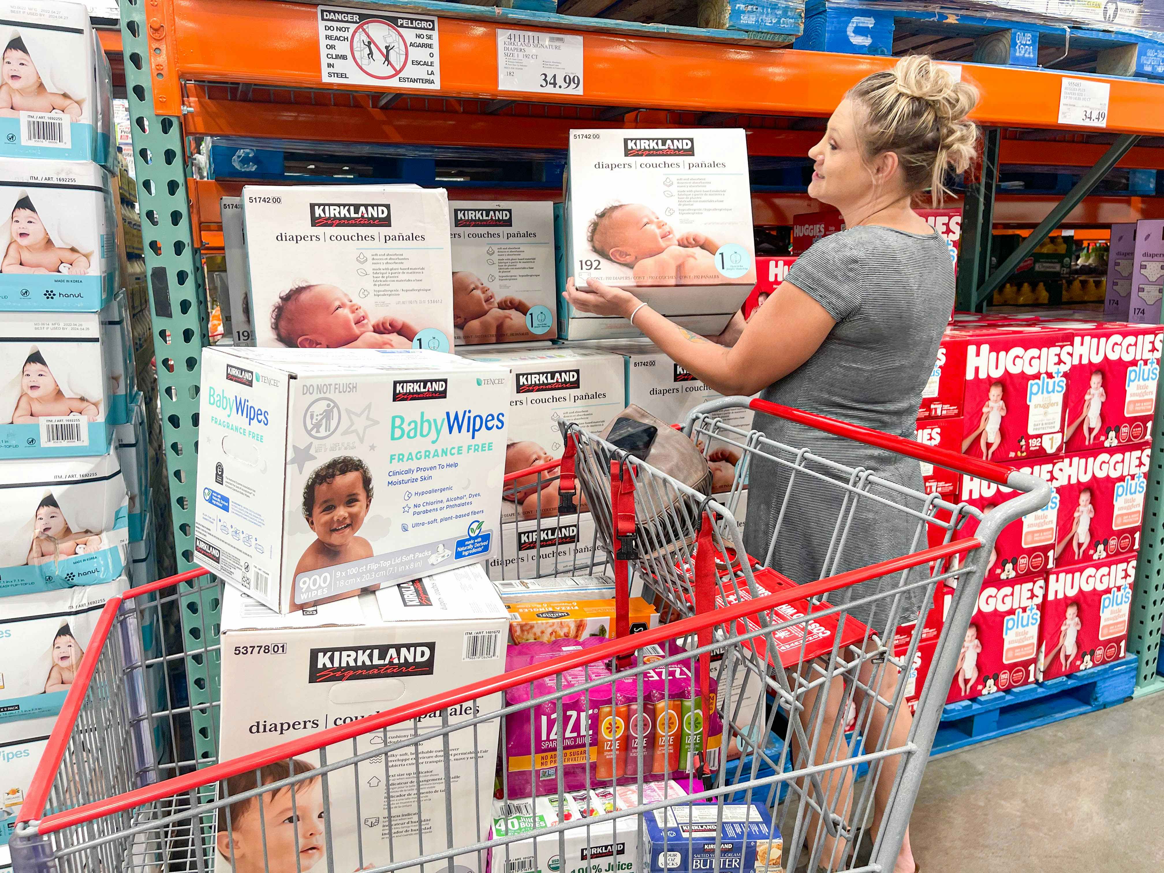 a woman looking at kirkland diapers and filling up cart