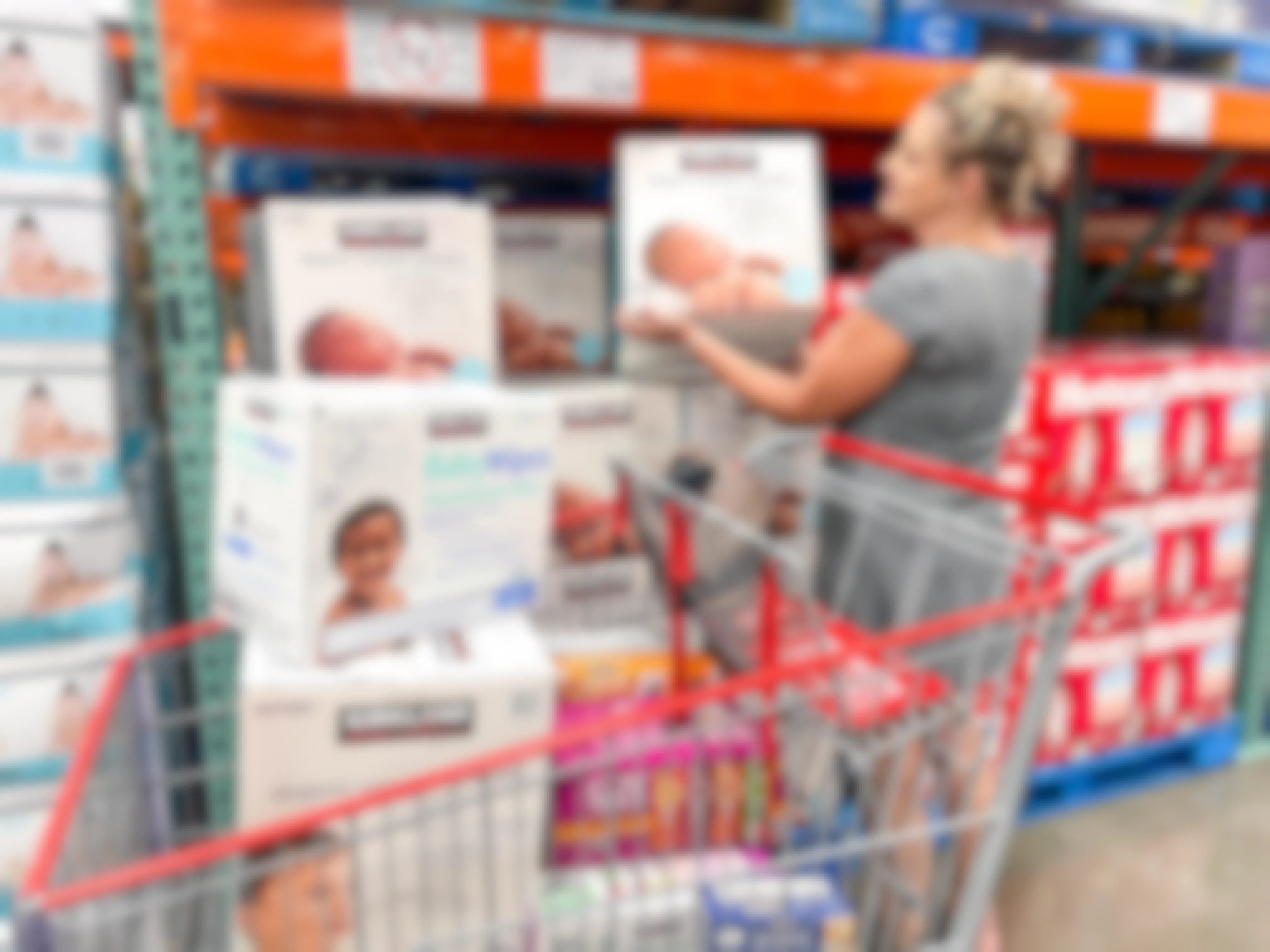 a woman looking at kirkland diapers and filling up cart