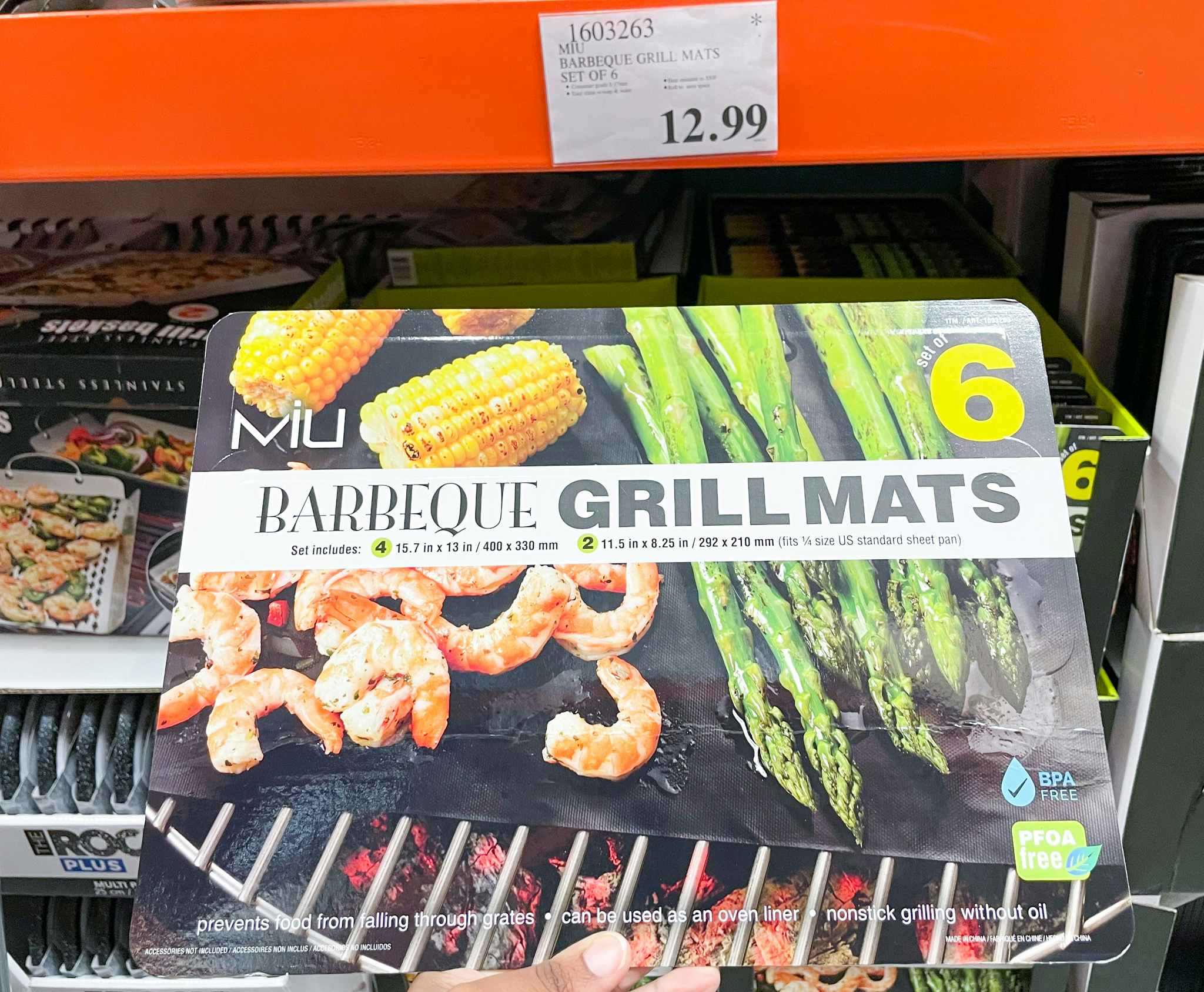 grill mats hand held near sale sign at costco