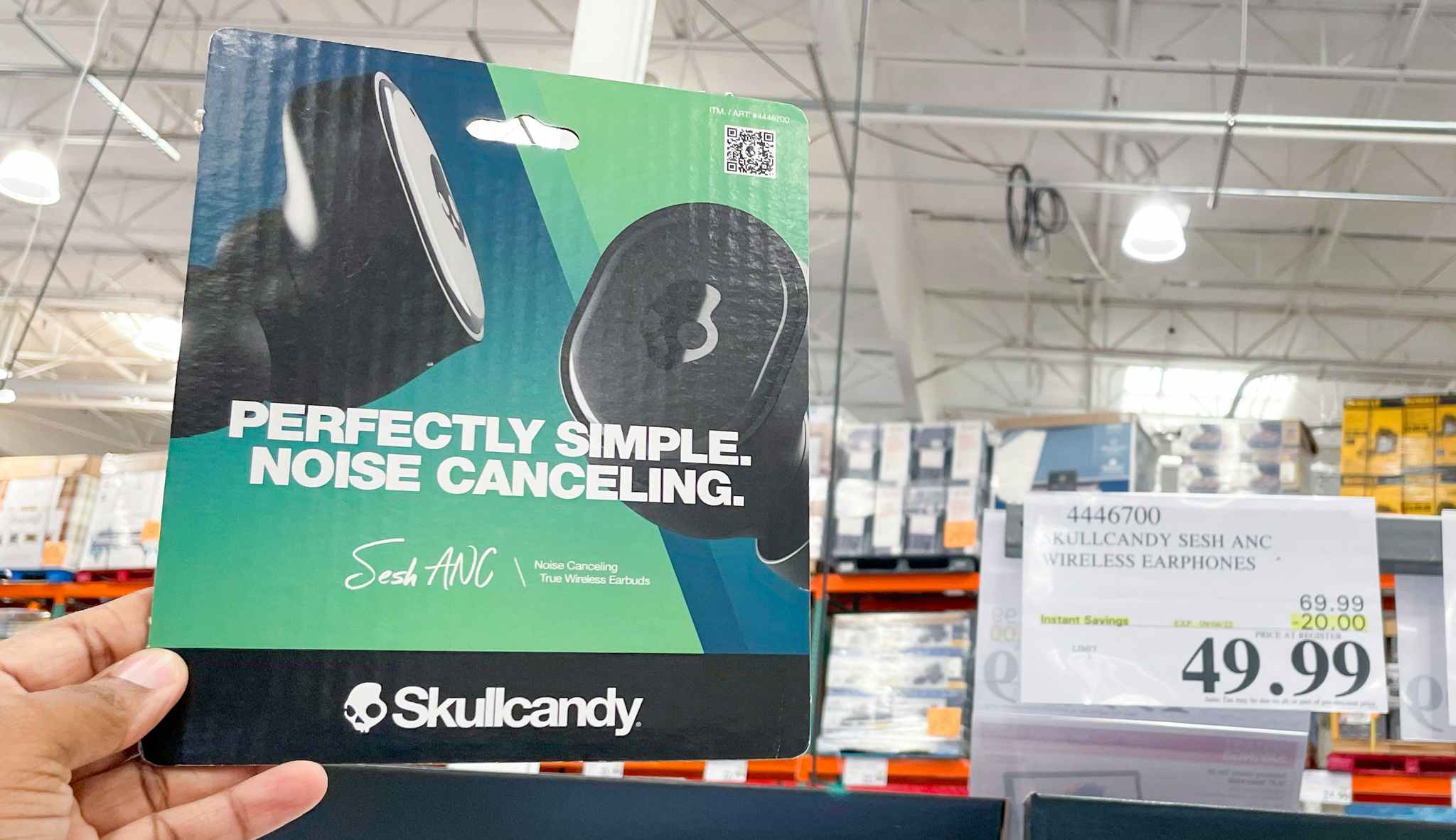 skullcandy headphones hand held near sale sign at costco