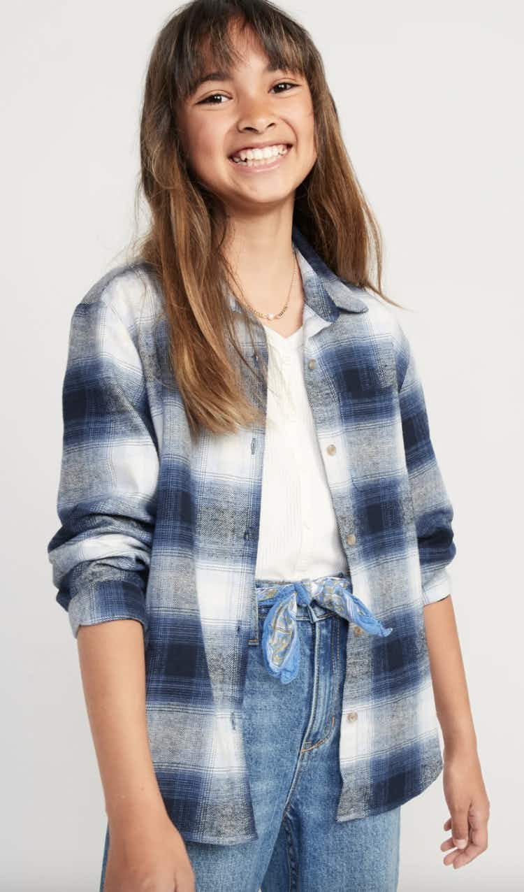 a young girl wearing a blue flannel shirt