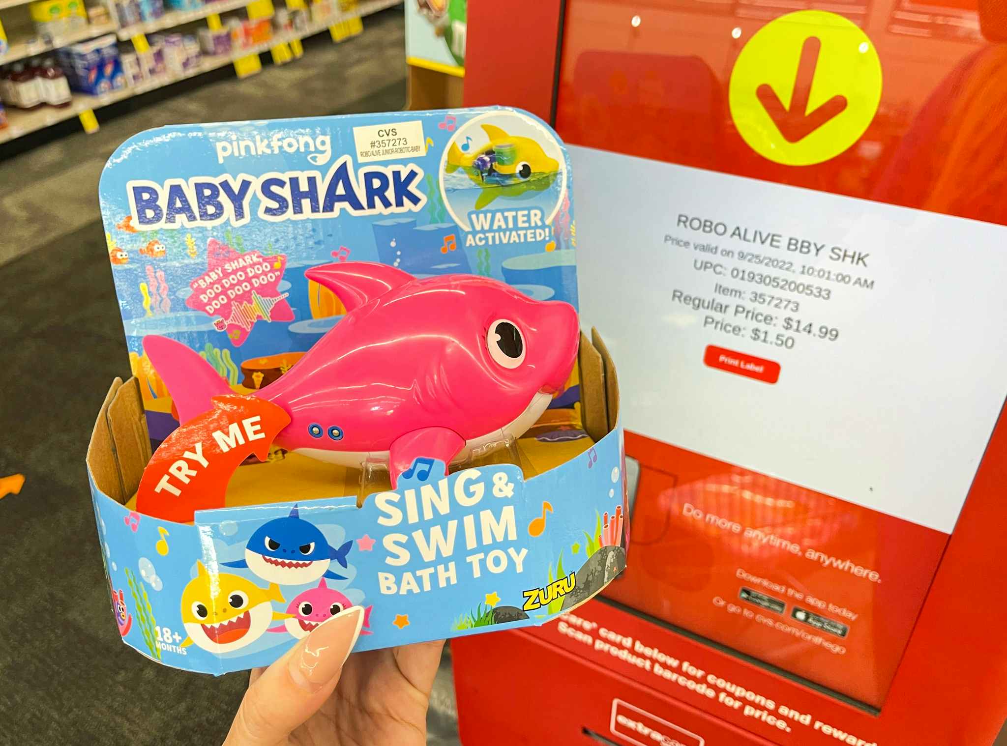 hand holding baby shark toy next to coupon center