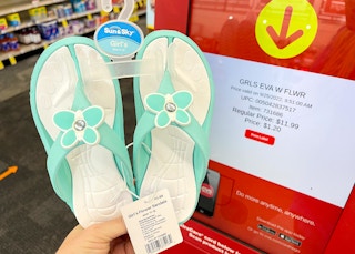 hand holding kids sandals next to coupon center