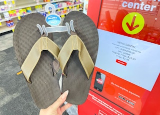 hand holding mens sandals next to coupon center