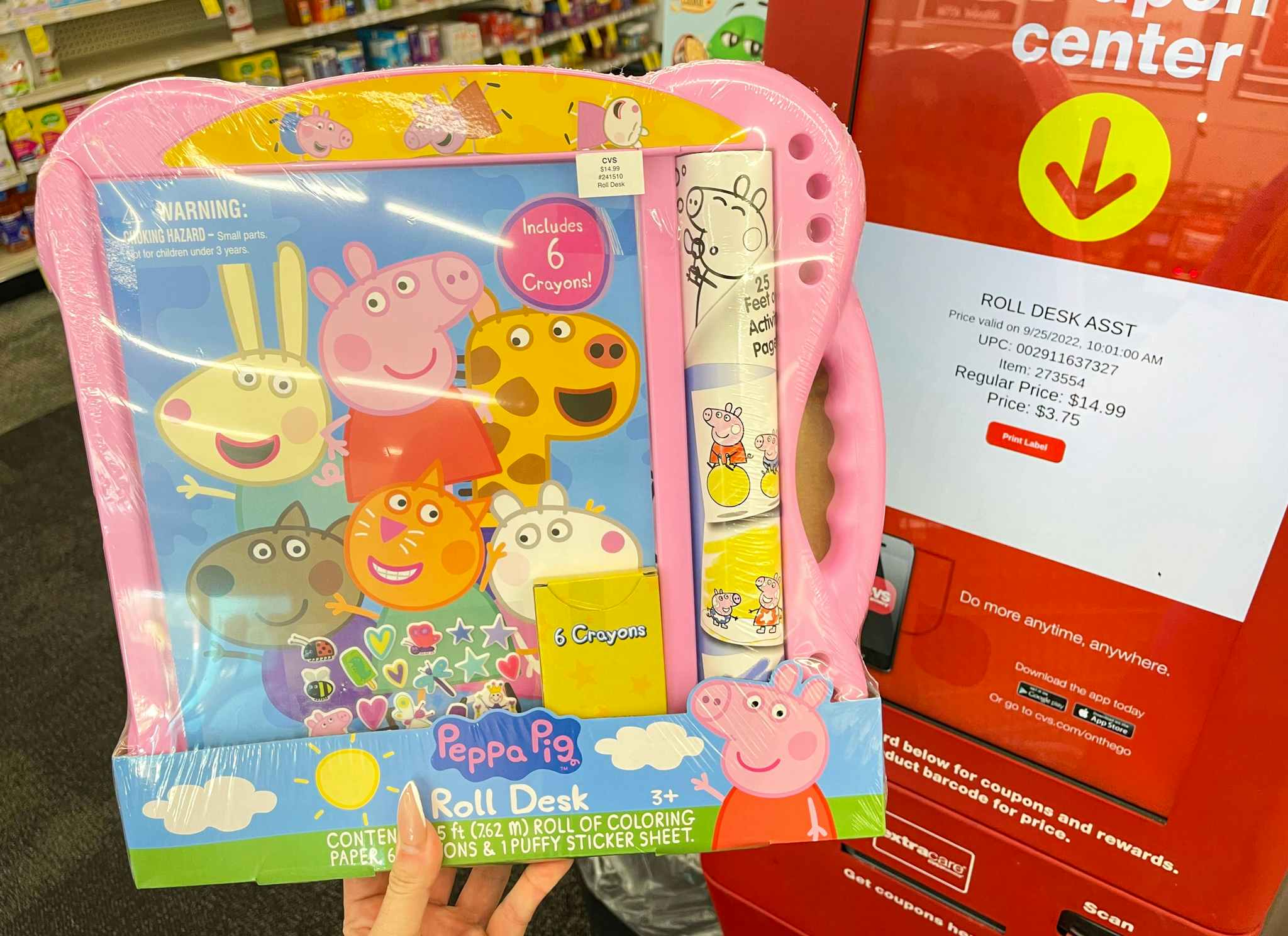 hand holding peppa pig toy next to coupon center