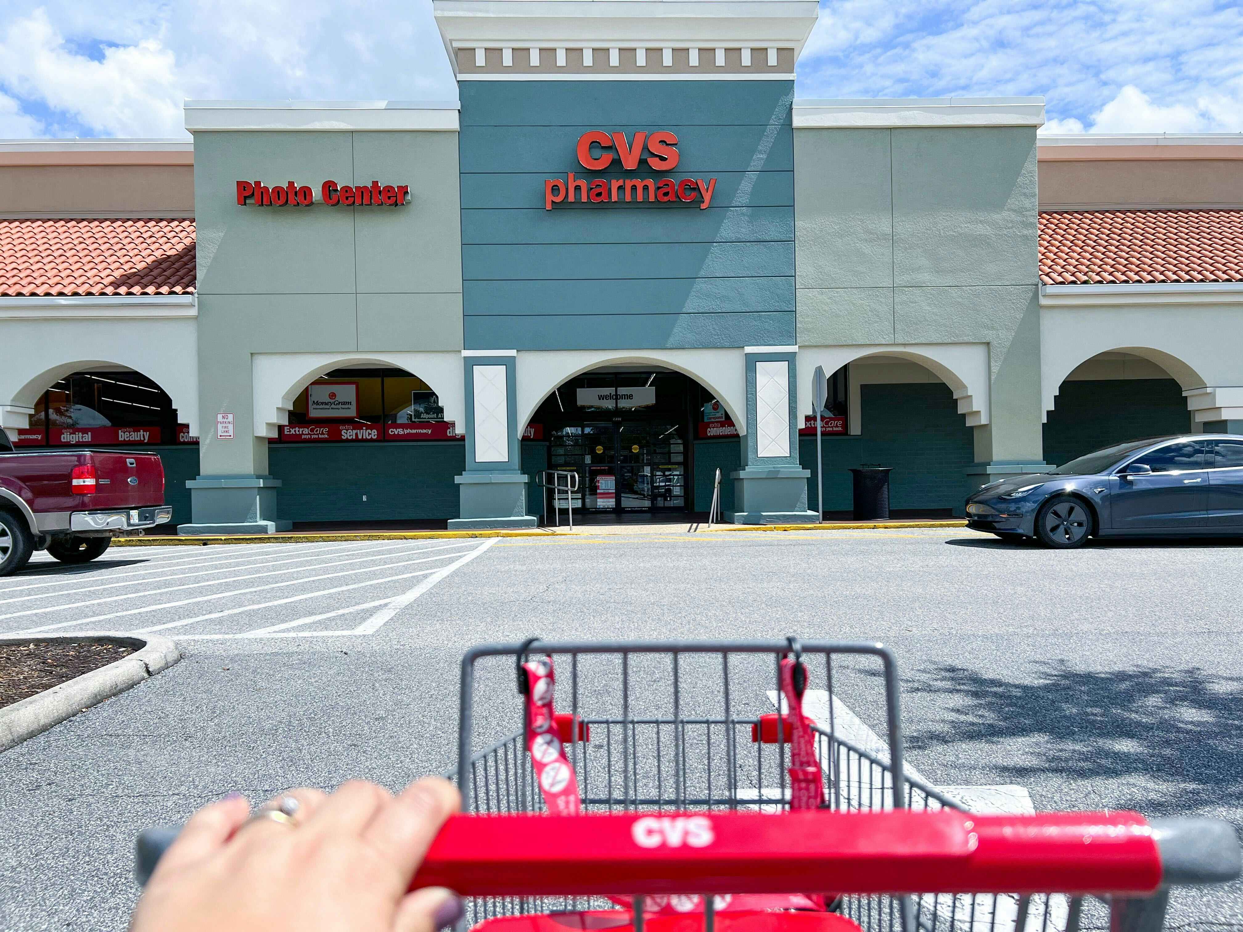 Hand pushing a shopping cart from the road into a CVS