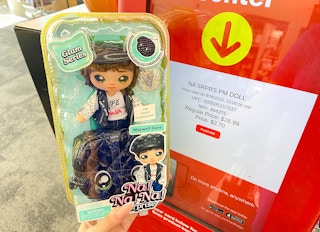 hand holding na na na surprise doll next to coupon center